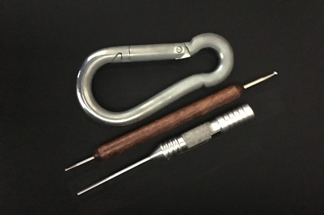 Carabiner and two pencil-shaped tools used for T.T.A.P.S